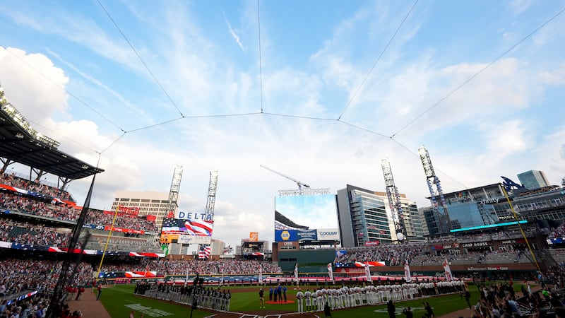 Military aircraft fly over Truist Park during the national anthem before a home-opening...