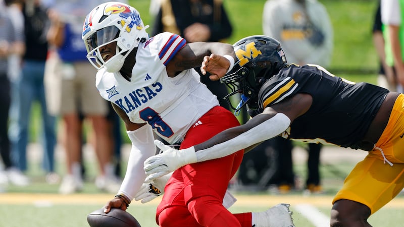 Kansas quarterback Jalon Daniels, is unable to get away from Missouri defensive end Zion...