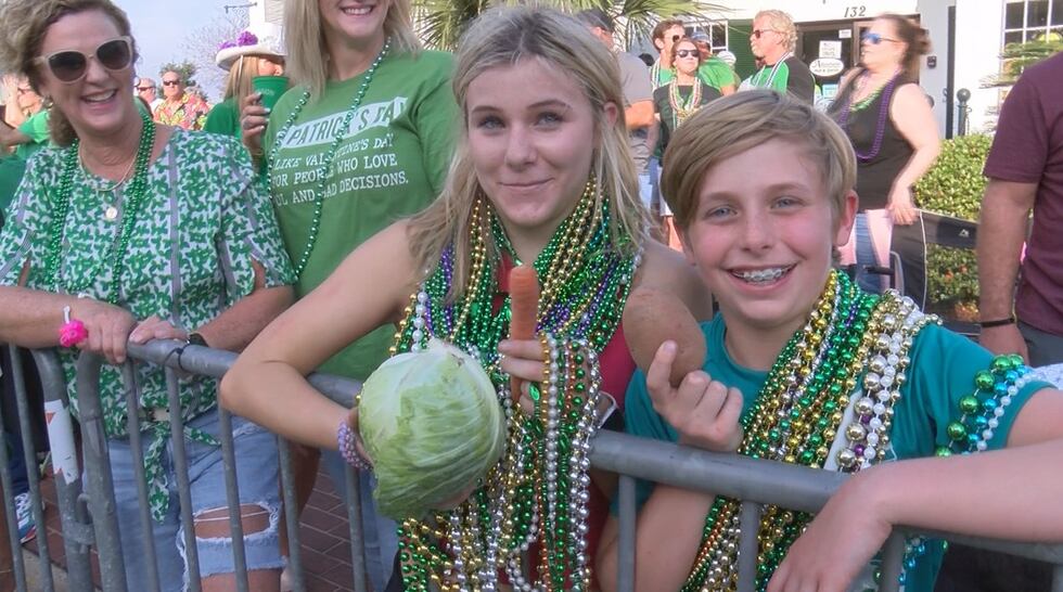 A couple of parade goers score some healthier throws typical of the Hibernia Irish Marching...