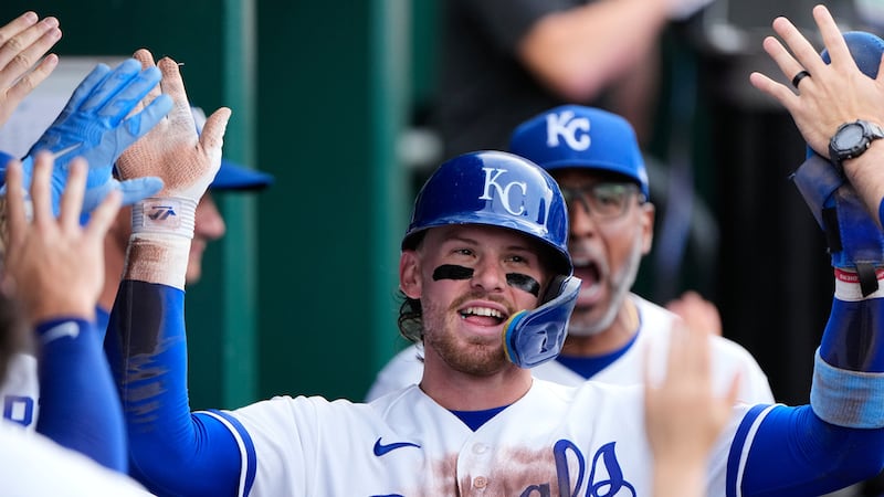 Kansas City Royals' Bobby Witt Jr. celebrates in the dugout after scoring on a double by...