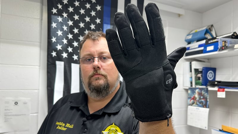 Justin Hall, custodio de la cárcel del condado de Nelson, en Kentucky, muestra un guante de...