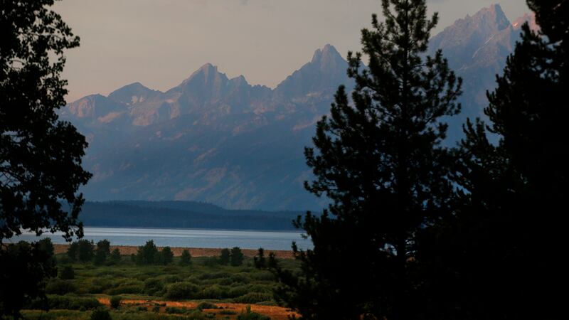 The morning sun illuminates the Grand Tetons at Grand Teton National Park, north of Jackson...