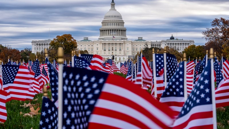 Banderas estadounidenses en miniatura ondean en el National Mall con el Capitolio al fondo, el...