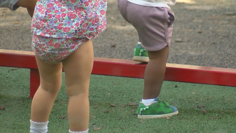 Two children play outside at a childcare facility. A new analysis finds Alabama families need...