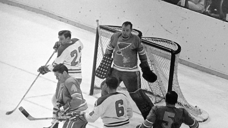 FILE - St. Louis Blues goalie Glenn Hall, top right, is pinned to his net waiting to make a...