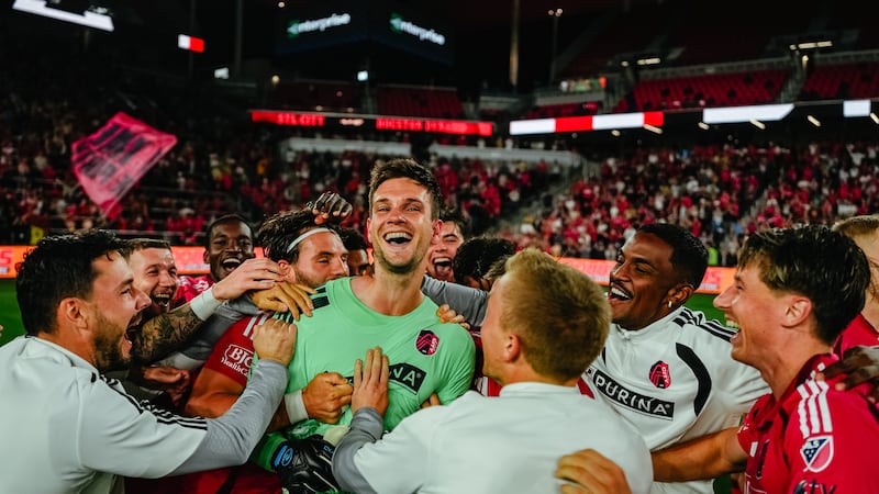 Goalkeeper Ben Lundt is mobbed by his teammates after saving two shots in a penalty shootout...