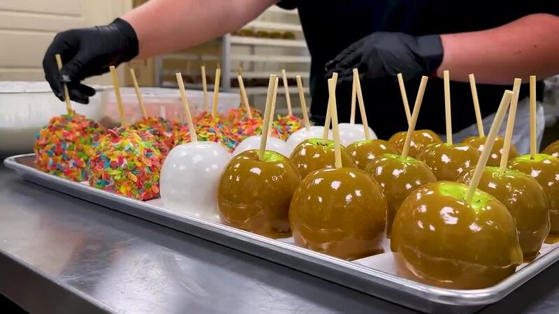 Preparing apples with chocolate, caramel, and goodies.