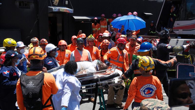 Rescatistas llevan a una persona sacada de entre los escombros del club nocturno Jet Set...