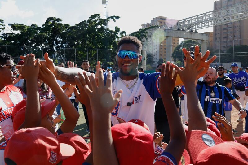 Atlanta Braves' Ronald Acuña Jr. high fives young participants during a baseball clinic at the Hugo Chávez baseball park in the Petare neighborhood of Caracas, Venezuela, Thursday, Nov. 6, 2025. (AP Photo/Cristian Hernandez)